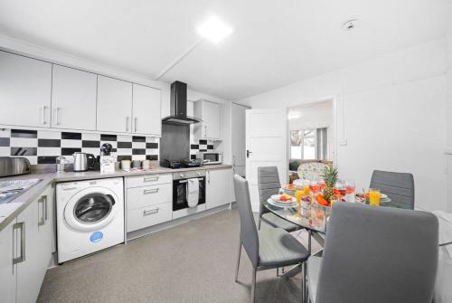 a kitchen with a table and chairs and a kitchen with white cabinets at ✪ 2-Bed Ground Floor Flat ✪Chelmsford✪ Prime Location in Chelmsford