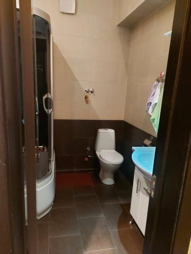 a bathroom with a toilet and a tub and a sink at GOAL Apartments 2 in Tbilisi City