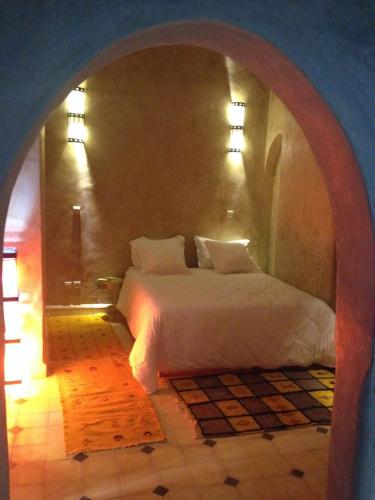 a bedroom with a white bed in an arch way at Kasbah Titrit & Spa in Aït Ben Haddou