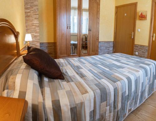 a bedroom with a large bed with a striped comforter at Legaire Etxea in Ibarguren