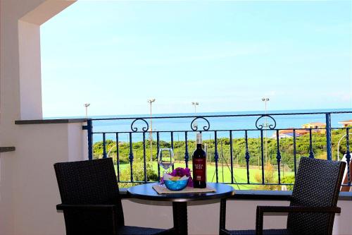 a table with a bottle of wine on a balcony at Hotel Rosa dei Venti in Castelsardo