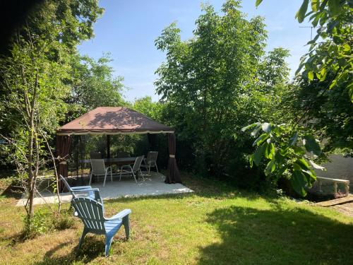 a gazebo with a table and chairs in a yard at Le petit monas in Civaux