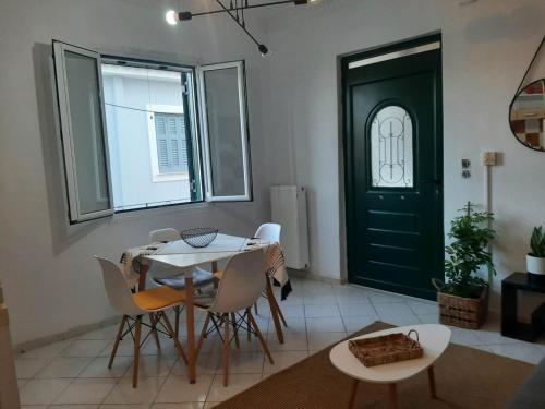 uma sala de jantar com mesa e cadeiras e uma porta verde em Evelina 4 em Lixúri