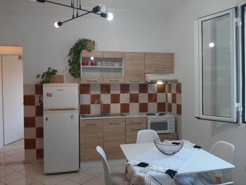 a kitchen with a white refrigerator and a table with chairs at Evelina 4 in Lixouri