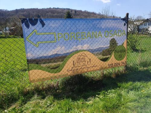 a sign on a fence that says porebana osada at Porębana Osada in Długopole-Zdrój