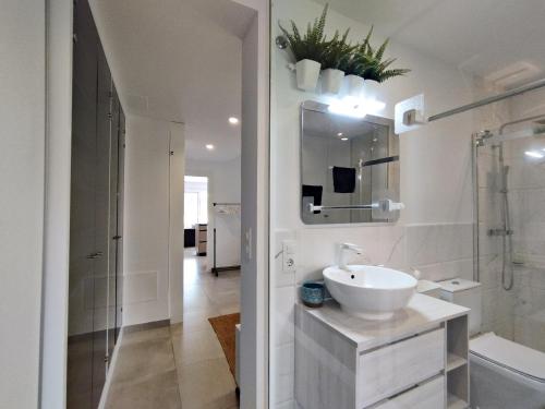 ein weißes Badezimmer mit einem Waschbecken und einem Spiegel in der Unterkunft Parque Vera IV FKK - Naturista in Vera