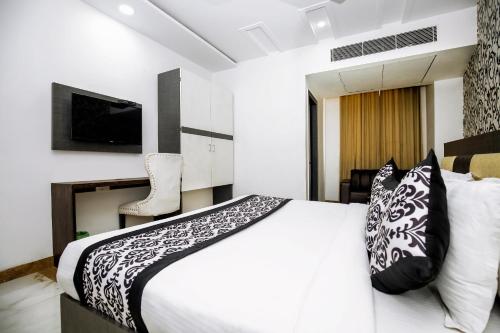 a bedroom with a white bed and a tv at Hotel A Star - 50 Meter From Golden Temple in Amritsar