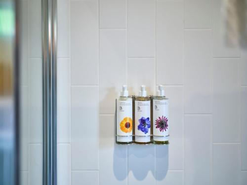 three candles are on a shelf in a bathroom at The Weeping Willow in Bury Saint Edmunds