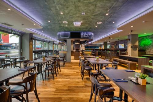 a restaurant with wooden tables and chairs and a tv at ibis Styles Hamburg Barmbek in Hamburg