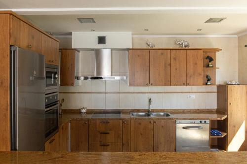 a kitchen with wooden cabinets and a stainless steel refrigerator at Legaire Etxea in Ibarguren