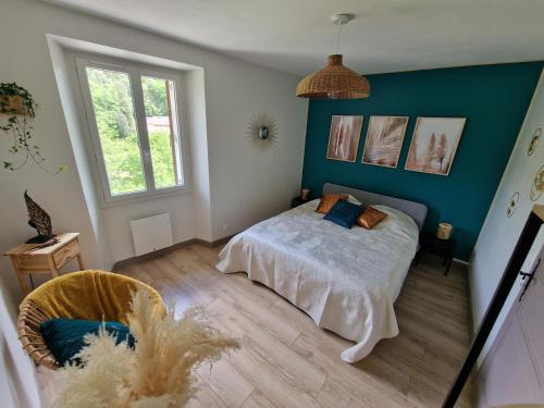 une chambre avec un lit et un mur bleu dans l'établissement La Messine, à Cros