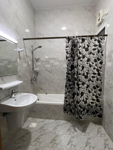 y baño con lavabo y bañera junto a un aseo. en Atlas Hotel Apartments, en Sohar