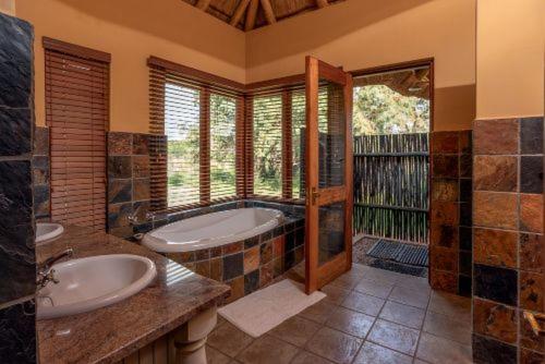 a large bathroom with two sinks and a tub at 23 Zebula - 4 Bedroom 14 Sleeper Home in Mabula