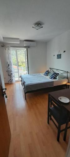 Un dormitorio con una cama y una mesa. en Apartmani Kljunak, en Zaton