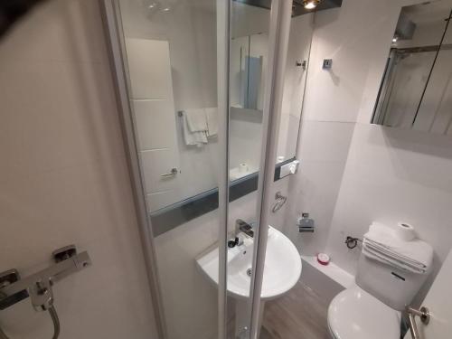 a white bathroom with a sink and a shower at Apartamento para 4 - Puerta del Sol in Madrid