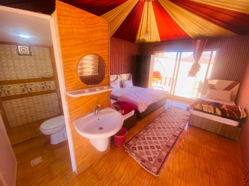 uma pequena casa de banho com uma cama e um lavatório em Nael Bedouin camp em Wadi Rum