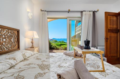 a bedroom with a bed and a table and a window at Appartamento Eleganza - SHERDENIA Luxury Apartments in Marinella