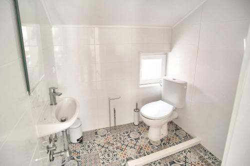 a white bathroom with a toilet and a sink at Bokeljski cvijet in Baošići