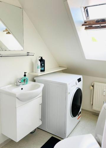 a white laundry room with a washer and dryer at Scandinavian Apartment Hotel - Prison Museum 2 - one room apartment in Horsens