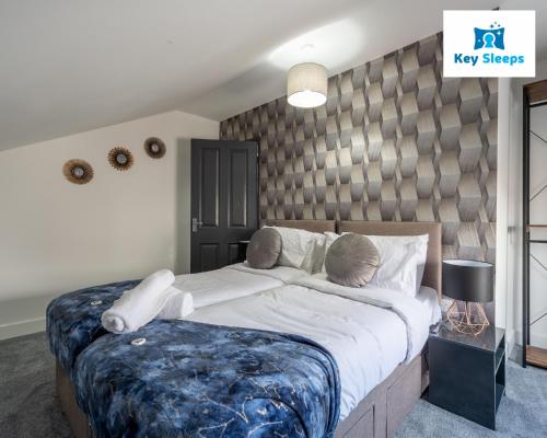 a bedroom with a large bed with a blue blanket at Five Bedroom Spacious Modern House By Keysleeps Short Lets Workington Lake District Beach in Workington