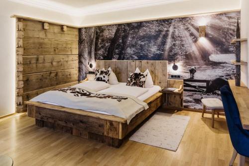 a bedroom with a large bed with a wooden wall at Wellness Natur Resort Gut Edermann in Teisendorf