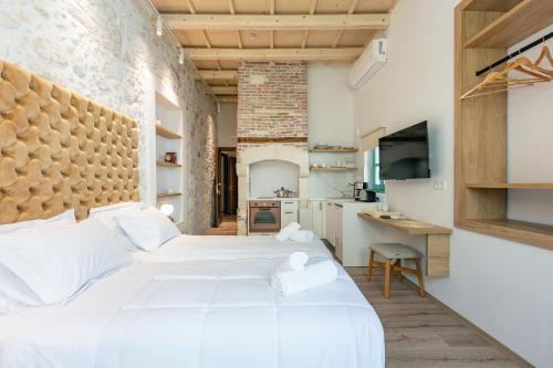 een slaapkamer met 2 witte bedden en een bureau bij La Luna della Loggia A1 in Rethimnon