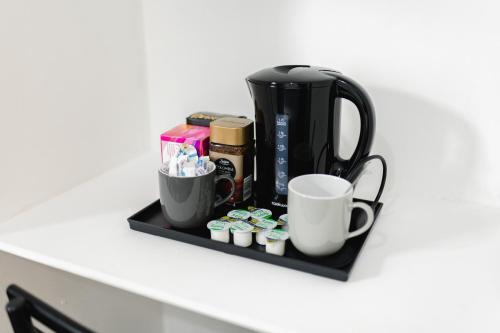 a shelf with a coffee maker and cups on it at Peaceful House near Pearson Park in Hull