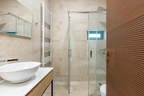 La salle de bains est pourvue d'un lavabo et d'une douche en verre. dans l'établissement La Luna della Loggia A1, à Réthymnon