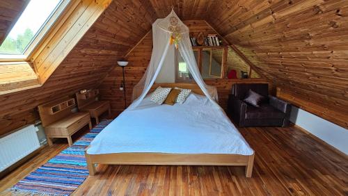 sypialnia z łóżkiem na drewnianym poddaszu w obiekcie Burziņi w mieście Kuldīga