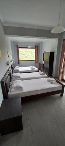 a large room with four beds and a window at Tsanis in Parga