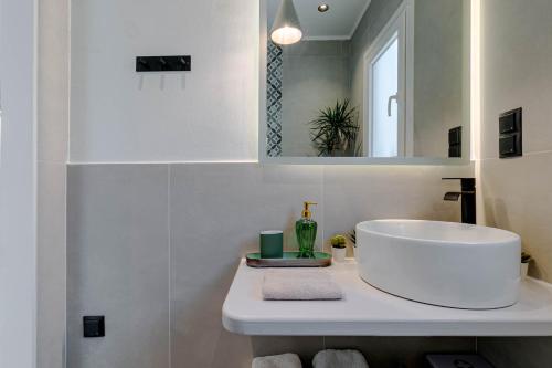 bagno con lavandino bianco e specchio di Terranova beach apartment - Menta a Ipsos