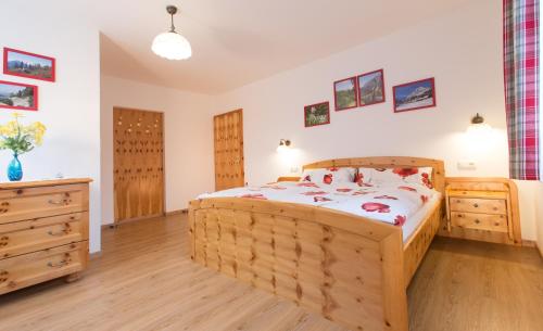 a bedroom with a wooden bed and wooden floors at Haus Moser in Wörschach