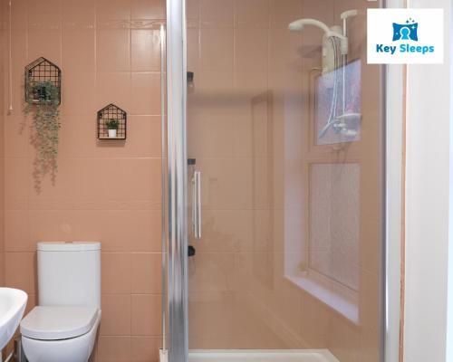 y baño con ducha, aseo y lavamanos. en Spacious Modern House At Keysleeps Short Lets Northampton With Free Parking Garden, 