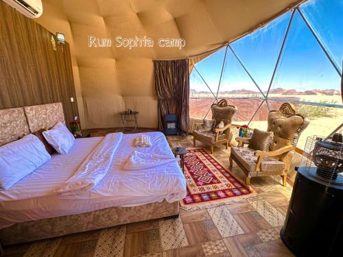 ein Schlafzimmer in einem Zelt mit einem Bett und 2 Stühlen in der Unterkunft Rum Sophia camp in Wadi Rum