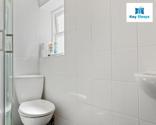 a white bathroom with a toilet and a sink at Spacious House By Keysleeps Short Lets Canterbury With Garden Contractors Leisure in Kent