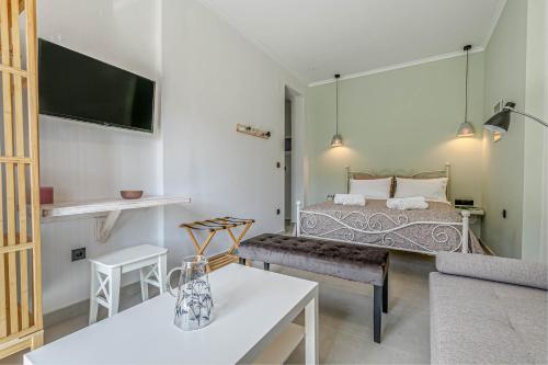 a room with a bed and a table and a couch at Terranova beach apartment - Menta in Ýpsos