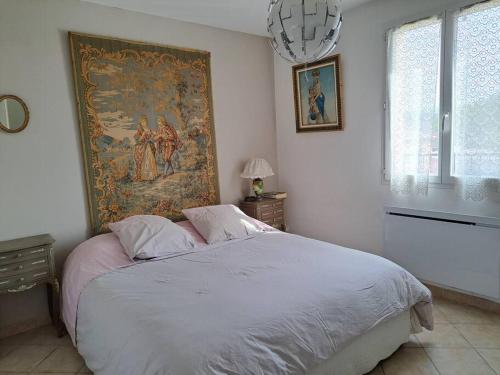 a bedroom with a bed with a large tapestry on the wall at Maison en Provence verte entre mer et lacs in Camps-la-Source