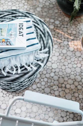 a basket with a stack of books on a table at Oustau Camarguen Hôtel & Spa in Le Grau-du-Roi