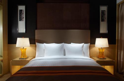 um quarto com uma cama grande e 2 candeeiros em Courtyard by Marriott Shanghai Central em Xangai