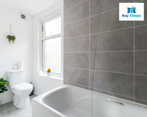 a bathroom with a white tub and a toilet at NEW Four Bedroom House By Keysleeps Short Lets Workington Contractor Leisure Beach Location Lake District in Siddick