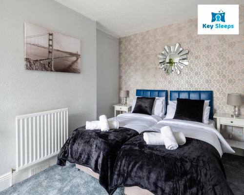 una camera da letto con due letti e un orologio a parete di NEW Four Bedroom House By Keysleeps Short Lets Workington Contractor Leisure Beach Location Lake District a Siddick