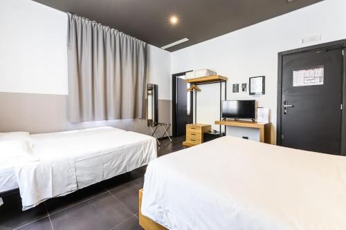 ローマにあるCentral Lodge Hotelのベッド2台とテレビが備わるホテルルームです。