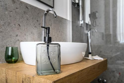 a glass bottle sitting on a wooden counter with a bowl at Central Lodge Hotel in Rome