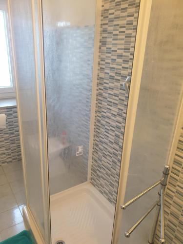 La salle de bains est pourvue d'une douche avec une porte en verre. dans l'établissement Location Turistic Antica dimora di Campagna Cir 00012, à Grazzano Badoglio