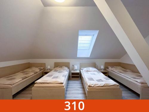 um quarto com 3 camas num sótão em SISI Pension em Púchov