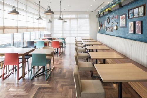 a row of tables and chairs in a restaurant at Hotel Folkloro Sanrikukamaishi in Kamaishi