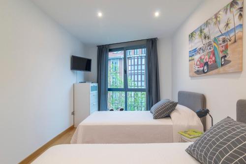 um quarto com 2 camas e uma janela em APARTAMENTO Holidea MATALEÑAS em Santander