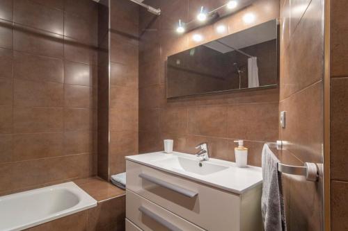 ein Badezimmer mit einem Waschbecken, einer Badewanne und einem Spiegel in der Unterkunft APARTAMENTO Holidea MATALEÑAS in Santander