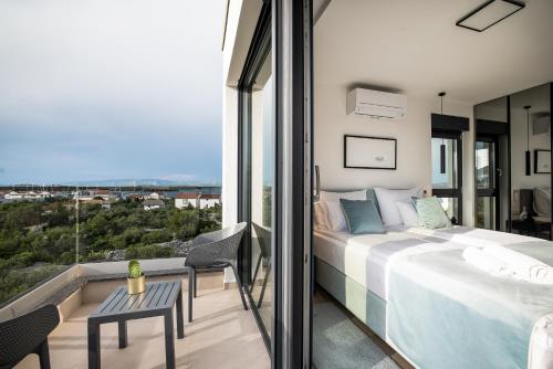 a bedroom with a bed and a balcony with a view at Villa Levant in Murter