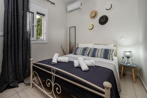 1 dormitorio con cama con almohadas y ventana en Aria Apartment, en Zakynthos